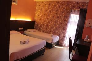 Postel nebo postele na pokoji v ubytování Bayu View Hotel Melaka