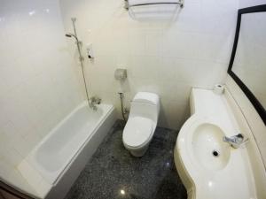 a bathroom with a toilet and a tub and a sink at Xcape Resort Taman Negara in Kuala Tahan