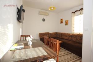 a living room with a table and a couch at Apartments Kojic in Bar
