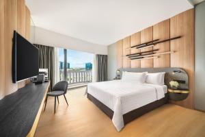 a bedroom with a bed and a flat screen tv at PARKROYAL COLLECTION Marina Bay, Singapore in Singapore