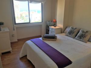 a bedroom with a large bed with a window at Cozy Apartment in a Beachfront Complex in Mareny Blau