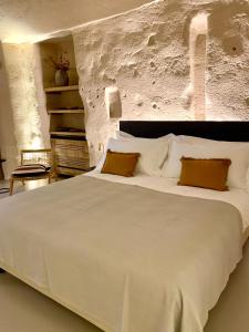 una camera da letto con un grande letto bianco con due cuscini di StageROOM02 - Matera a Matera