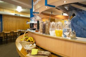 eine Cafeteria mit einer Theke mit Gläsern und Essen in der Unterkunft Mont-Fort Swiss Lodge in Le Châble