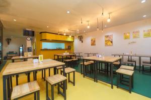 - un restaurant avec des tables et des chaises dans une salle dans l'établissement RedDoorz @ Taman Galaxy Bekasi, à Cikunir Satu