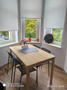 une table à manger avec des chaises et une horloge dans l'établissement Herman View Apartment, à Grudziądz