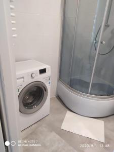- un lave-linge dans la salle de bains pourvue d'une fenêtre dans l'établissement Herman View Apartment, à Grudziądz