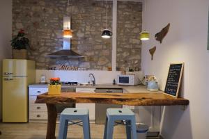 una cucina con piano di lavoro in legno e sgabelli blu di OlioeAlloro B&B a San Vincenzo
