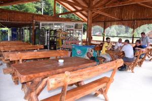 Eine Gruppe von Menschen, die in einem Gebäude an Tischen sitzen in der Unterkunft CABANUTE si CAMPING DRACULA in Căpăţîneni-Pămînteni