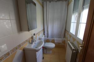 baño con lavabo y aseo y ventana en Las Riendas casa rural en Muñeca