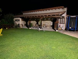 un patio trasero con cenador y césped verde en Las Riendas casa rural en Muñeca