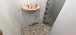 a bathroom with a pink sink on a wall at Limasan Mbah Darmo in Tepus