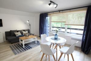 a living room with a couch and a table and chairs at Ośrodek Wypoczynkowy AKWA Marina in Nysa