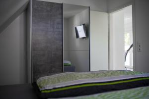 um quarto com uma cama com um espelho e uma televisão em Ferienwohnung in der Mainleite für Zwei em Baunach