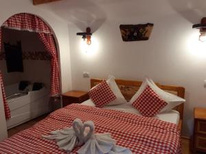 Schlafzimmer mit einem Bett mit einer roten und weißen Tagesdecke in der Unterkunft CABANUTE si CAMPING DRACULA in Căpăţîneni-Pămînteni
