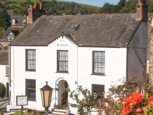 een wit huis met een zwart dak bij St Vincent Guest House in Lynton