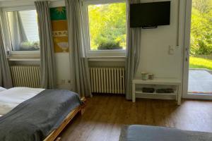 Schlafzimmer mit einem Bett und einem Flachbild-TV in der Unterkunft Bergische Oase - Ferienwohnung Oskar in Overath