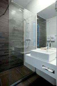 a bathroom with a sink and a glass shower at Hotel Ecu in Genk
