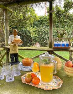 un hombre sosteniendo un plato de comida y una bandeja de zumo en Charm Azenha DÓbidos Farm, en Olho Marinho