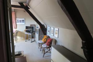 克勒伊斯貝爾亨的住宿－B&B / Studio De Druivelaar in hartje Kluisbergen (Berchem)，一间带椅子和桌子的房间以及一台电视