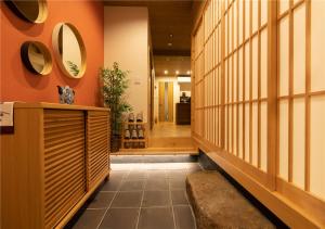 um corredor com paredes cor de laranja e espelhos na parede em 谷町君・星屋・秋の家 em Quioto