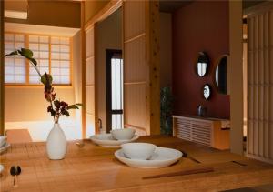 um quarto com três tigelas numa mesa com um vaso em 谷町君・星屋・秋の家 em Quioto