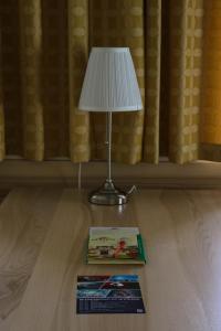 a lamp sitting on a table next to a book at Familiengasthof Maier in Mautern in Steiermark