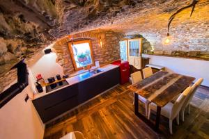 een eetkamer met een tafel en een stenen muur bij La Cachette CIR 0001 in Aosta