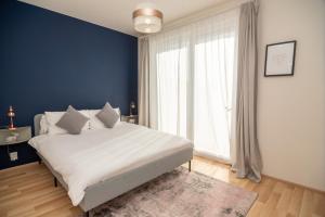 a bedroom with a large white bed and a large window at 3 bed modern family house in Mikulov in Mikulov