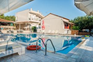 ein Pool mit Stühlen und ein Hotel in der Unterkunft Kalypso studio Resorts in Kavos