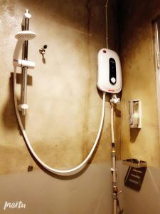 a shower in a bathroom with a phone on the wall at Loft Pals Urbanstay Lodge, Kapit in Kapit +205 photos