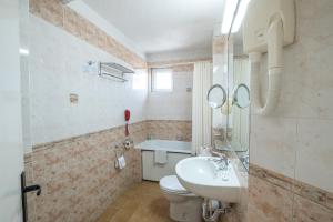 a bathroom with a white sink and a toilet at Noviz Hotel in Plovdiv