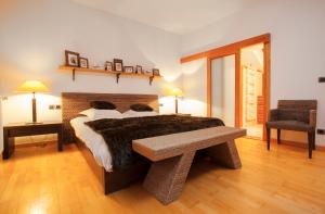 1 dormitorio con cama y banco. en L'appart du chateau des Girards, en Lans-en-Vercors