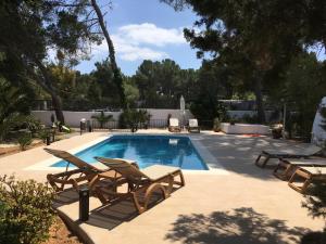 - une piscine avec 2 chaises longues et une table dans l'établissement Chalet Torralba - Villa at Hotel Osiris, à Sant Antoni de Portmany