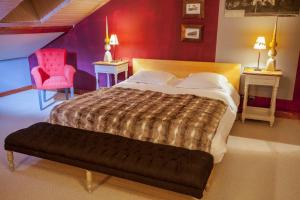 una camera con un grande letto e una parete rossa di L'appart du chateau des Girards a Lans-en-Vercors
