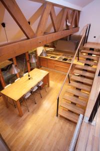 Habitación con mesa de madera y escalera de madera. en L'appart du chateau des Girards, en Lans-en-Vercors