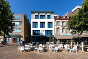 um grupo de mesas e cadeiras em frente a um edifício em Mr Jigs em Venlo