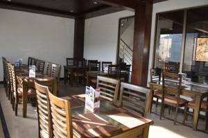 a dining room with wooden tables and chairs at Hotel Royal Inn in Murree