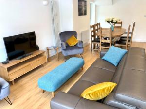 ein Wohnzimmer mit einem Sofa, einem TV und einem Tisch in der Unterkunft 'Sea Breeze' Dorset dream holiday home in Poole