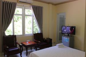 头顿林宋酒店的一间带床、电视和窗户的卧室