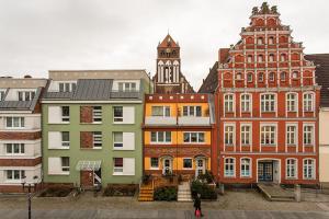 a group of buildings in a city with a clock tower at H&H Apartments im Herzen der Stadt teilweise mit Balkon ruhig zentral modern mit Küche in Greifswald