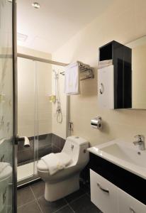 a bathroom with a toilet and a sink and a shower at ERNES Hotel in Perai