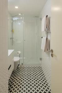 a bathroom with a shower and a black and white tile floor at Morar Apartments Porto in Porto
