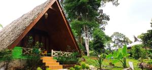 een klein huis met een rieten dak bij Green Forest Tangkahan in Tangkahan