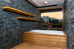 a bathroom with a bath tub in a brick wall at Apartmány DeLuxe Lomnica in Veľká Lomnica