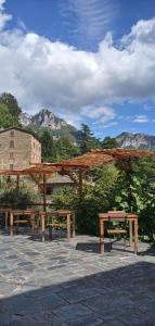 a group of benches sitting under a wooden pavilion at Pania forata hostel in Stazzema