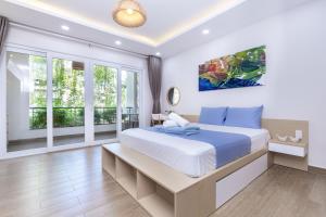 a bedroom with a large bed and a balcony at Cozrum Homes - Yoga Corner in Ho Chi Minh City