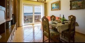 a dining room with a table and a view of the ocean at Mali Marino 1 in Selce