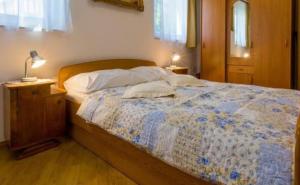 a bedroom with a bed with a night stand and a lamp at Mali Marino 1 in Selce