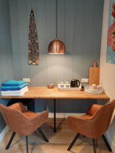 een houten tafel met twee stoelen en een lamp bij B & B Tulp Amsterdam Noord in Amsterdam