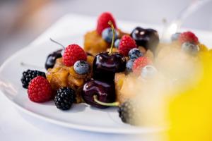 a plate of food with berries and fruit on it at ODELYA - Stadthotel im Park in Basel